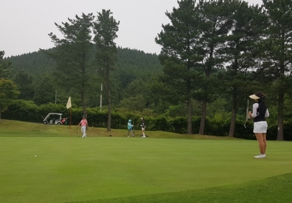 축제에 참가한 회원들이 그린에서 퍼팅을 하고 있다