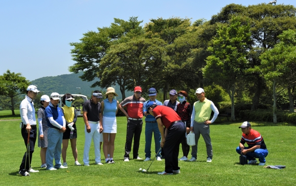 조승태 웨스턴골프사관학교 교육원장의 어프로치 샷 시범을 지켜보고 있는 곽구근 사장(맨 오른쪽 앉은 사람)